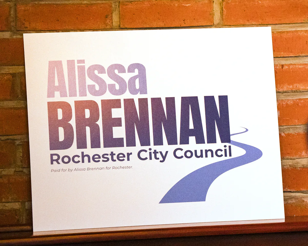 An Alissa Brennan for Rochester City Council lawn sign against a brick wall